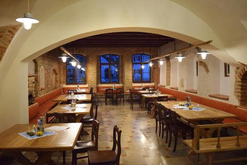 un restaurante con mesas y sillas de madera y ventanas en Wirgarten Antik Hotel, en Dingolfing