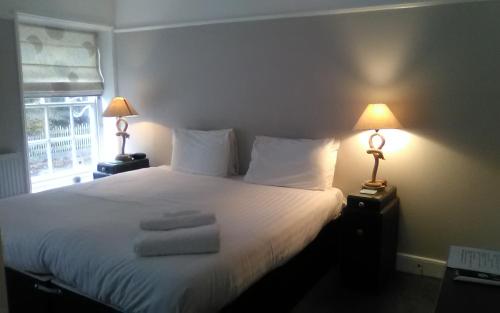 a bedroom with a white bed with towels on it at The Boathouse in Sutton Bridge