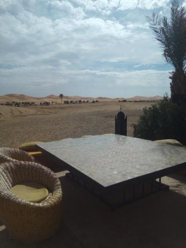 a table in the middle of the desert at Sahara Desert Camp in Hassilabied