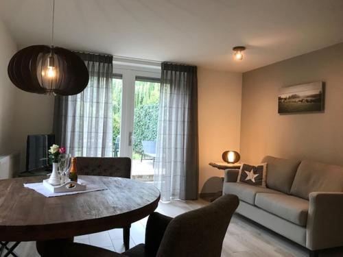 een woonkamer met een tafel en een bank bij Hotel Hoeve de Plei in Mechelen