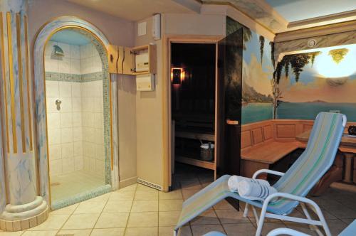 a bathroom with a shower and a chair in a room at Hotel Gasthof Stoanerhof in Mayrhofen