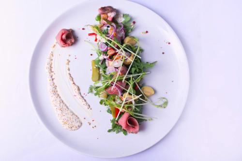 a white plate with a salad on it at ARTHOTEL STALOWA 52 in Warsaw