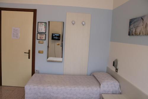 a small room with a bed and a mirror at Hotel O'Scugnizzo 2 in Belluno