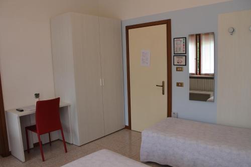 a bedroom with a bed and a desk and a chair at Hotel O'Scugnizzo 2 in Belluno