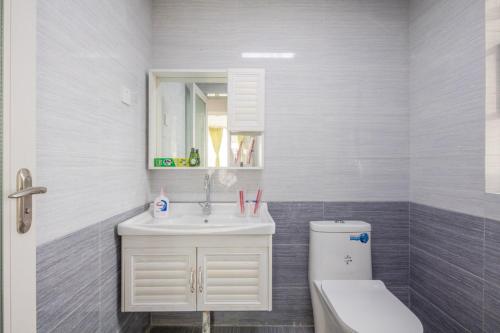 La salle de bains est pourvue d'un lavabo, de toilettes et d'un miroir. dans l'établissement ChengDu JinNiu·ChunXi Road Locals Apartment 00129440, à Chengdu