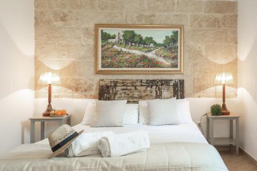 1 dormitorio con 1 cama con una pintura en la pared en B&B Aurora Salentina, en Morciano di Leuca