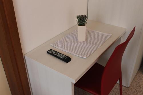 a table with a remote control and a vase on it at Hotel O'Scugnizzo 2 in Belluno