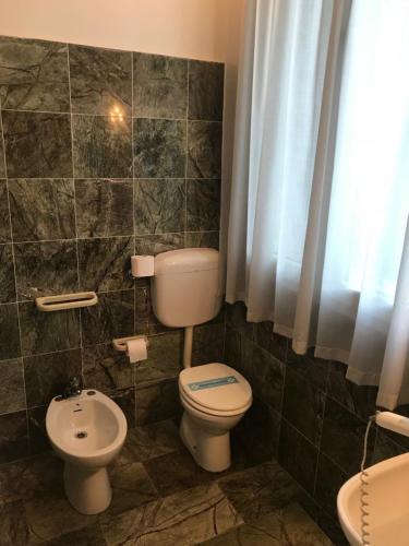 a bathroom with a toilet and a sink at Villa Carrer in Porto Viro