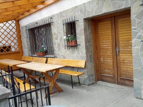 patio con mesa de madera, bancos y puerta en Sklep u Kunických - apartmán, en Vracov