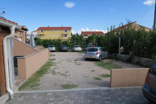 a parking lot with cars parked in it at Family Apartment in Baška