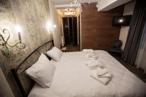 a bedroom with a bed with white towels on it at Wine Hills in Tbilisi City