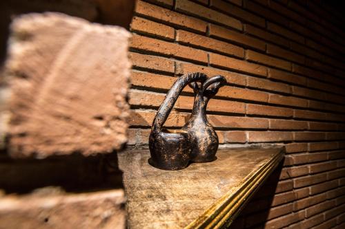 a statue of a dog sitting on a ledge next to a brick wall at Wine Hills in Tbilisi City