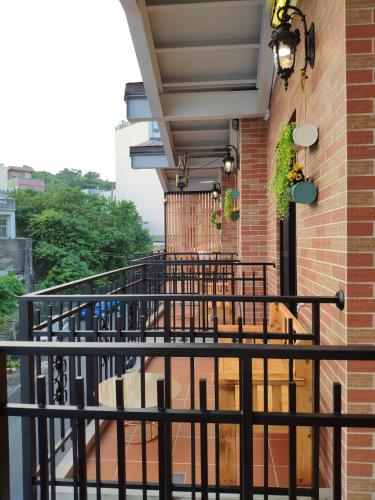 a balcony with a black railing next to a brick building at Teacher Cai Homeestay in Xiaoliuqiu