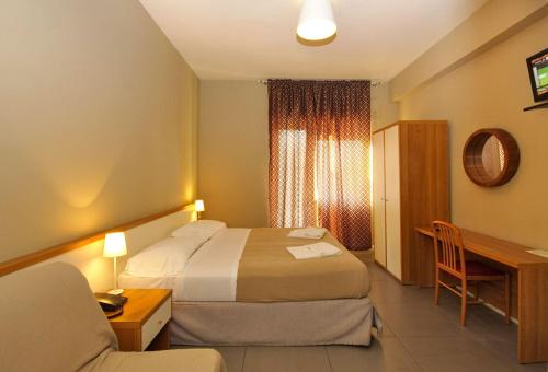 a hotel room with a bed and a desk and a chair at City Guest House in Rome