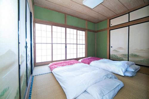 two beds in a room with two windows at Gran kodachi in Fujikawaguchiko