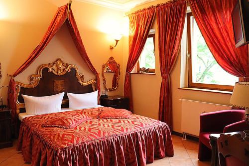 um quarto com uma cama com uma colcha vermelha e 2 janelas em Albergo City Hotel Berlin em Berlim