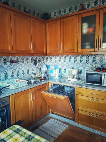 a kitchen with wooden cabinets and blue and white tiles at Casa Celeste in Castro Daire