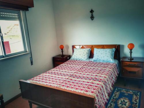 1 dormitorio con 1 cama con edredón rojo y blanco en Casa Celeste, en Castro Daire
