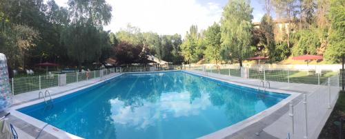 a large swimming pool with a fence around it at Hotel Resort Cueva del Fraile in Cuenca