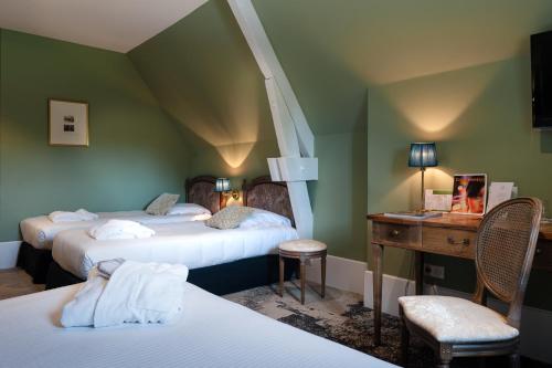 a hotel room with two beds and a desk and a room at Domaine de Saulon in Saulon-la-Rue