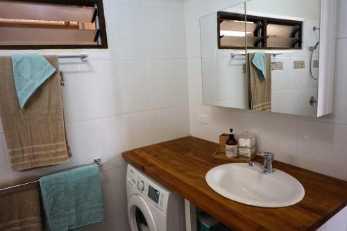 a bathroom with a sink and a washing machine at Aoredise in Luganville