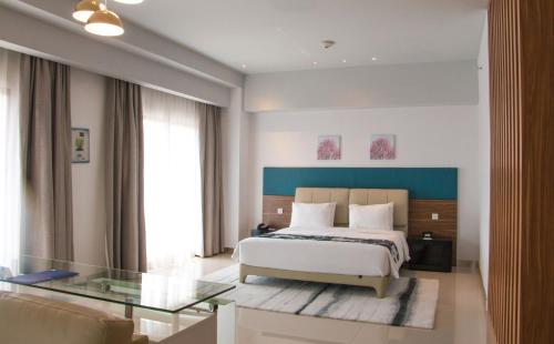 a bedroom with a bed and a glass table at Holiday Inn Express Baruna by IHG in Kuta