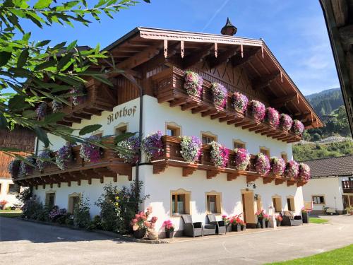 a building with flowers on the balconies at Urlaub am Bauernhof Rothof in Sankt Johann im Pongau