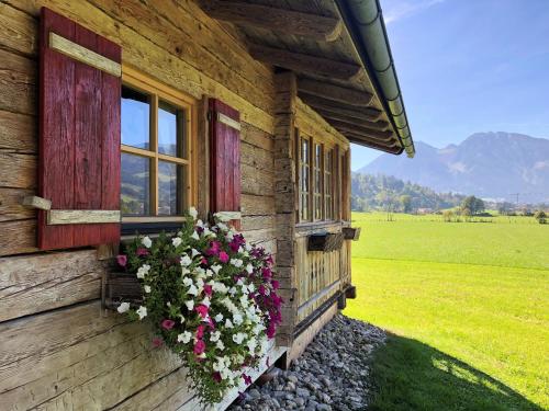 a wooden house with flowers on the side of it at Urlaub am Bauernhof Rothof in Sankt Johann im Pongau