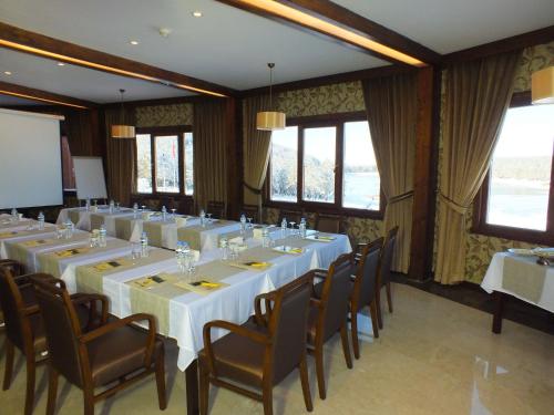 a conference room with white tables and chairs and windows at Fenerbahçe Serkan Acar Resort&Sports Topuk Yaylası in Dereceören