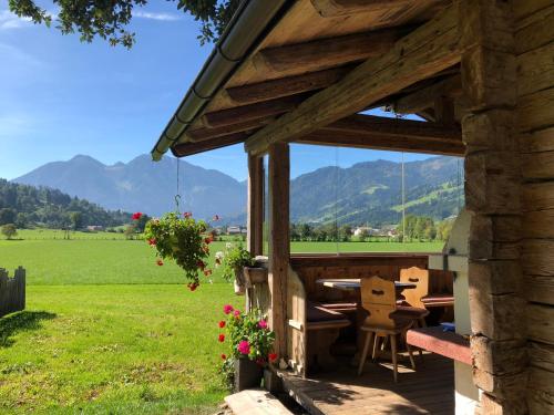a wooden building with a table and chairs in a field at Urlaub am Bauernhof Rothof in Sankt Johann im Pongau