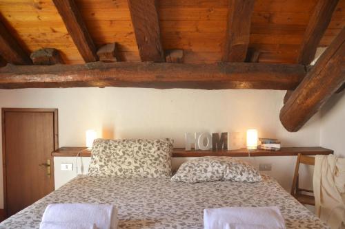 a bedroom with a bed with wooden ceilings at Casa la Terrazza sul Lago - WelcHome in Cannobio