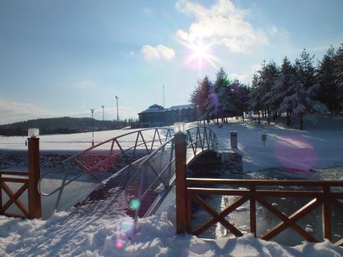 a playground covered in snow with the sun in the background at Fenerbahçe Serkan Acar Resort&Sports Topuk Yaylası in Dereceören