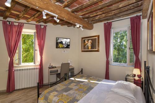 um quarto com uma cama, uma secretária e 2 janelas em Art Gallery B&B em Vorno