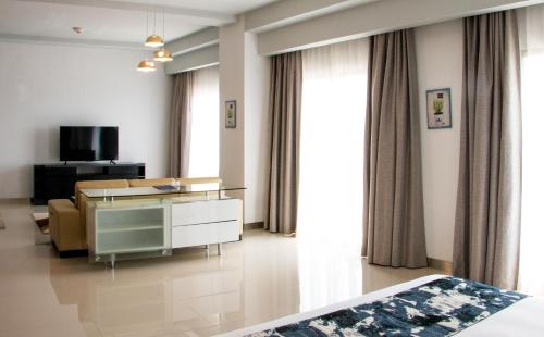 a hotel room with a bed and a desk and a tv at Holiday Inn Express Baruna by IHG in Kuta