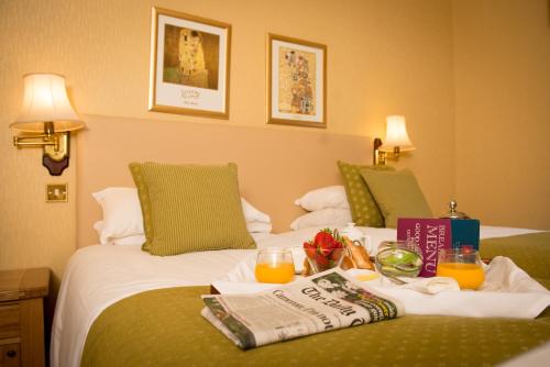 a hotel room with a tray of food on a bed at Glen-Yr-Afon House Hotel in Usk
