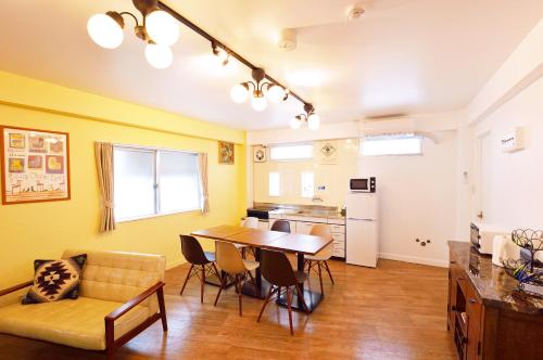 a kitchen and dining room with a table and a couch at Douce in Ginowan