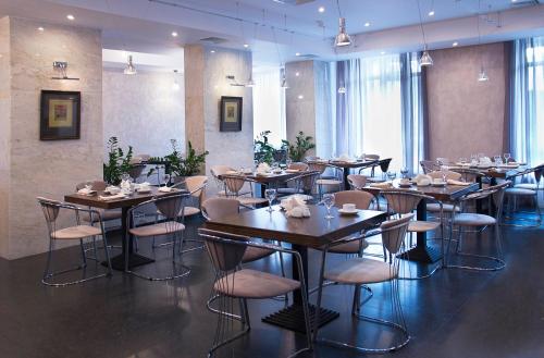 a dining room with tables and chairs in a restaurant at Osnabruck Hotel in Tver