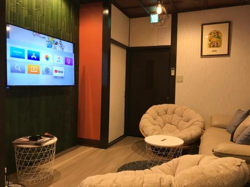 a living room with a couch and a flat screen tv at Family house (private house) in Osaka