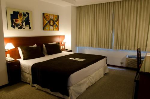 a hotel room with a large bed and a window at HM International Hotel in Guayaquil