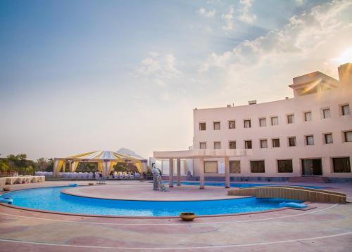 a building with a pool in front of a building at Spectrum Resort, Spa & Residences in Udaipur