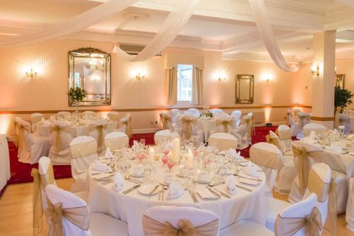 a room full of tables and chairs with white linens at Glen-Yr-Afon House Hotel in Usk