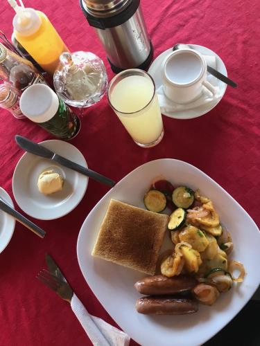 a table with a plate of food with eggs and toast at Samuka Island Retreat in Jinja