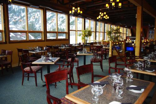 a dining room with tables and chairs and windows at Waterton Lakes Lodge Resort in Waterton Park