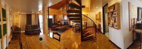 uma sala de estar com uma escada em espiral numa casa em HOMESTAY DE MARQS - STYLISH and SPACIOUS 3 BEDROOM VACATION HOME em Baguio