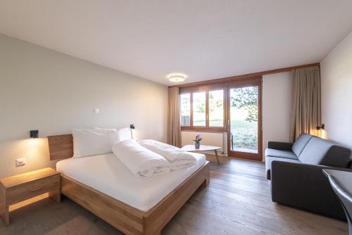 Rüti的住宿－Noah Hotel，一间卧室配有一张床和一个沙发