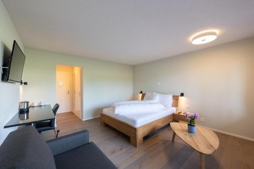 a bedroom with a bed and a couch and a table at Noah Hotel in Rüti