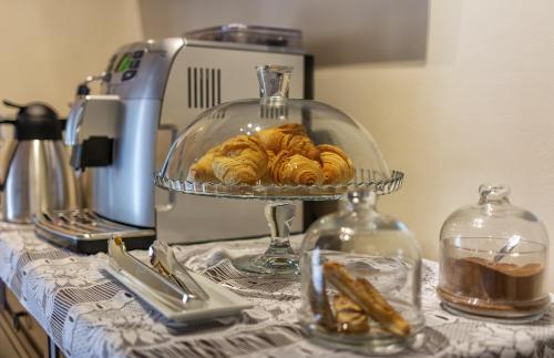 a plate of croissants on a counter with a mixer at Art Gallery B&B in Vorno