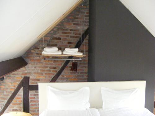 a room with a white bed and a brick wall at Amosa Liège City Centre Hotel in Liège