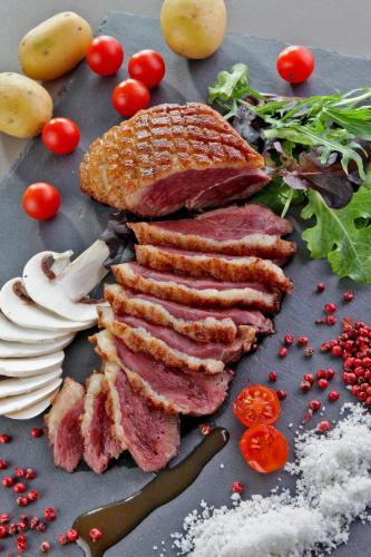 a group of meat and vegetables on a table at L'Aquitaine - Cahors Sud in LʼHospitalet