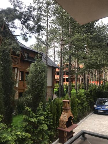 a view of a house with a car parked in a yard at Lux Apartman Daria in Zlatibor